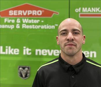 SERVPRO employee in front of green truck