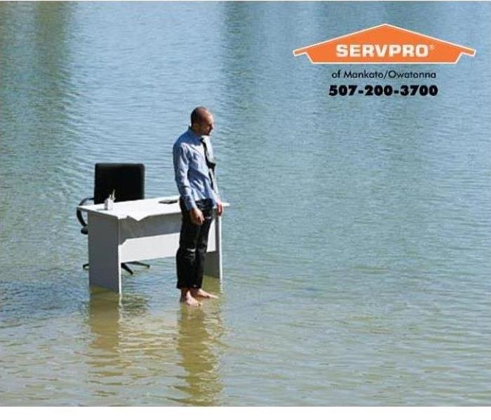 A person stands in a flooded office space